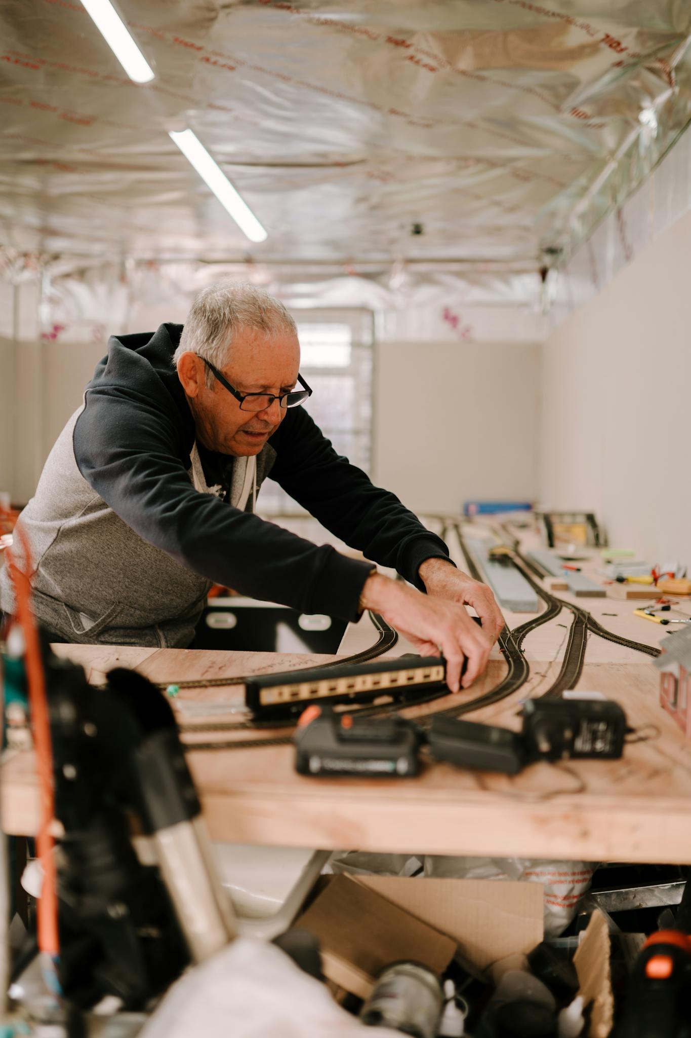Man adjusts model train set on table